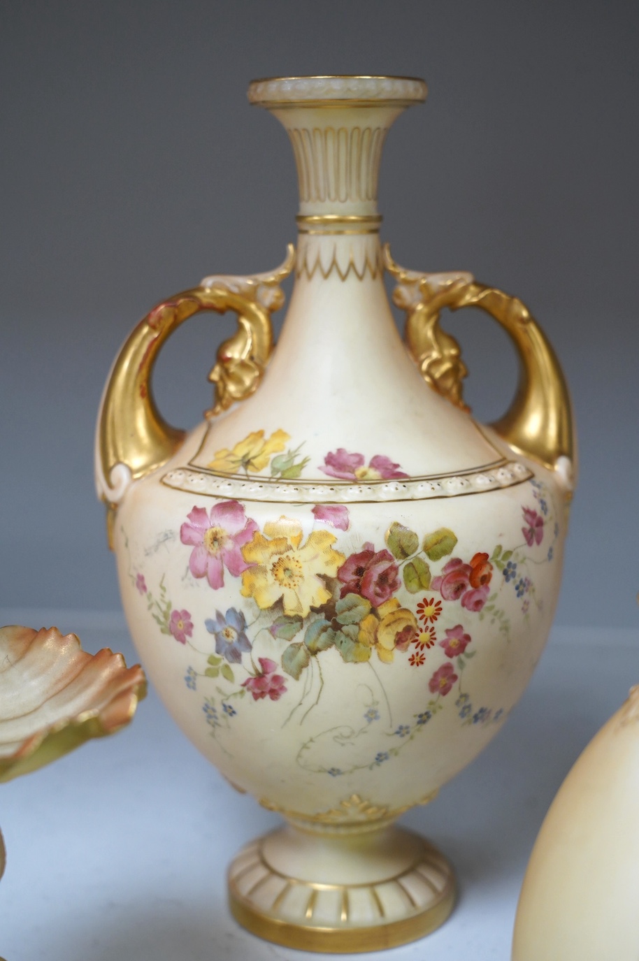 Royal Worcester blush ivory ornamental items: including a vase, two pots and covers, two dolphin stands, a cup and saucer and pierced bowl and cover (8). Condition - fair to good